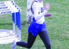 Sprinting down the backstretch of the track, Karsyn Grimes races for the Gibbon girls in the 200 meter dash at Kenesaw. (—photo by Steve Glenn)
