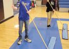 Trae Bly sweeps the gym floor before practices for the Shelton boys basketball team along with Shelton paraeduator Dori Ropers. (–courtesy photo) Article Image Alt Text