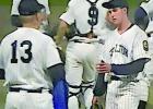 Thompson, coaches, and fellow players talk in-game strategy during a baseball game.
