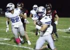 Riley Bergstrom tucks the ball and runs around the end for good yardage in the season ending football game against Arcadia/Loup City. (—photo by Alissa Baxter)