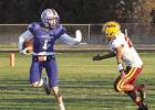 Riley Bombeck fends off a Sterling tackler on his way to another nice gain in the first round playoff game last Friday. (—photo by Steve Glenn) Bulldogs advance in D6 playoffs by grounding Jets