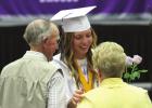 Jenna Rauert, a member of the graduating Class of 2022 at Wood River Rural High School, presents her family members with flowers during the graduation ceremonies held last Sunday. (–photo by Barb Berglund) Graduation held for Wood River Rural High Class of 2022