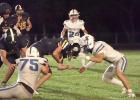 Gibbon’s Tyler Hodges (#75) gets an Elm Creek ball carrier’s leg wrapped up, while teammate Ivan Tamayo uses his shoulder to stop forward motion, during last Friday night’s football contest. (—photo by Alissa Baxter)