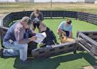 Working on the Gaga Ball Pit they fundraised for as a STEM project are Bentley Samuelson, Jaxton Swarm, and Blake Herter. Not pictured is Jordan Clevenger. Also pictured helping with the installation of the ball pit is Gibbon school buildings and grounds 