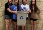 Members of the Gibbon WIN class, left to right, Brynlee Lambert, Landry Ureste, Piper Reid and Emerie Gartner, show recycling bins they painted the recycling symbol on for each elementary classroom as part of their recent STEM project which also included 