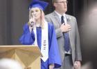 Shelton High graduate Lyndee Kautz performs the National Anthem as Secondary Principal Jeremy Weiseler looks on during commencement ceremonies for the Class of 2019 on Saturday. (–photo by Steve Glenn) Article Image Alt Text
